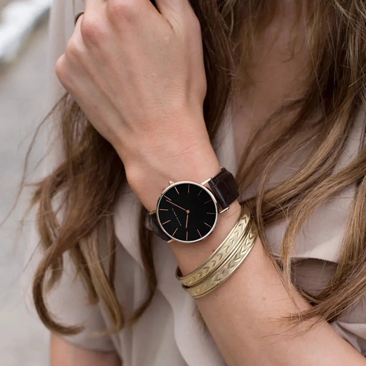 Women’s wristwatch with a 36mm rose-gold case, black dial and brown leather strap.