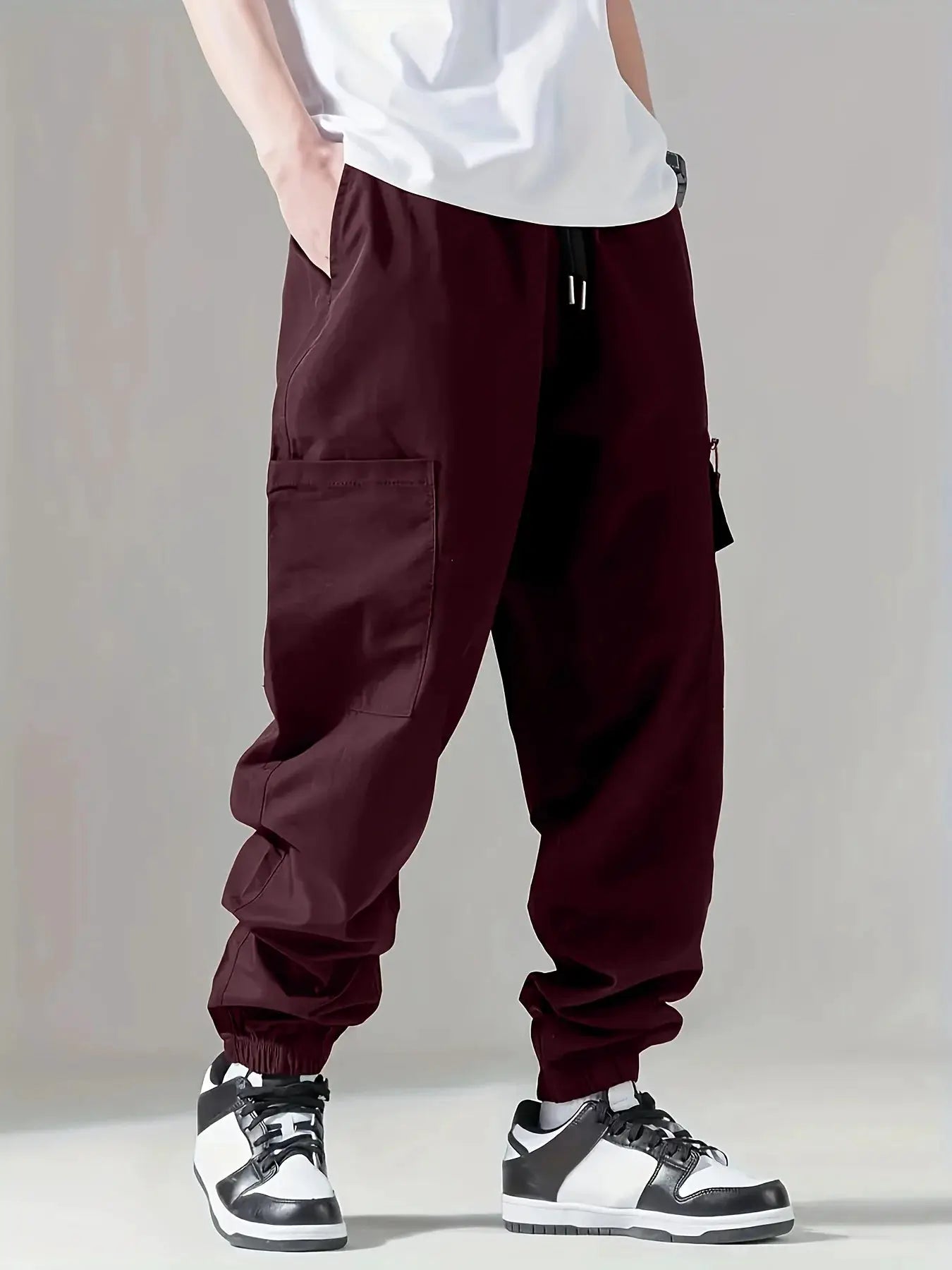 Men's maroon cargo pants with side pockets and drawstring waist, breathable fabric.