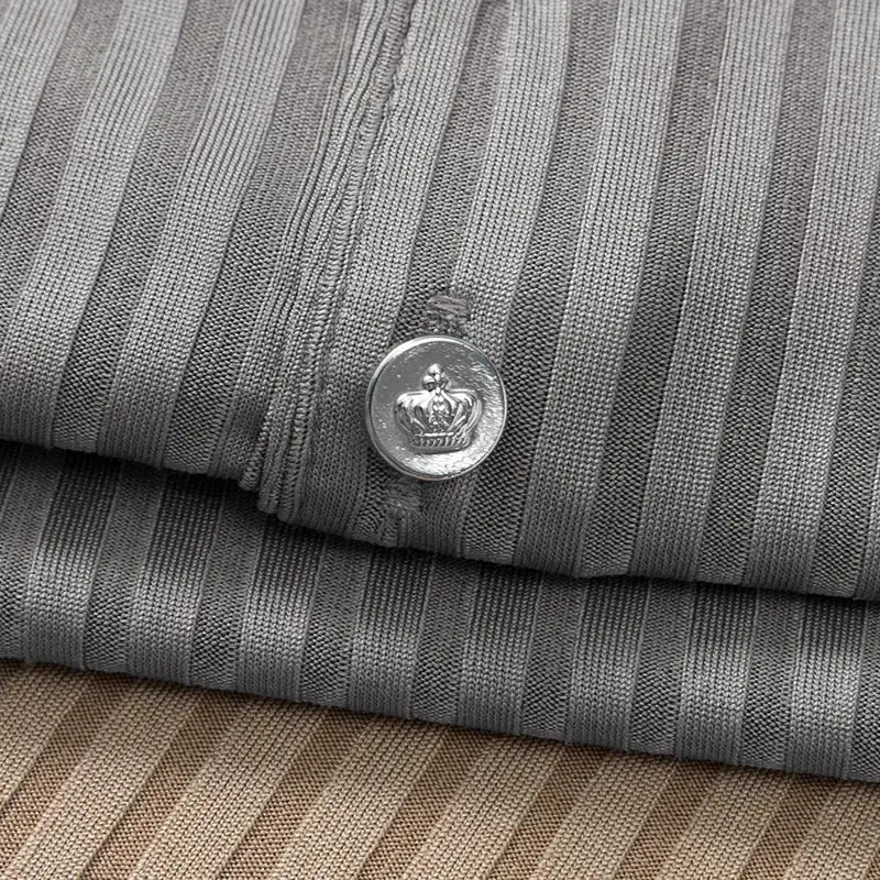 Men's striped polo shirt fabric close-up in gray and beige tones with a metal button featuring a crown emblem