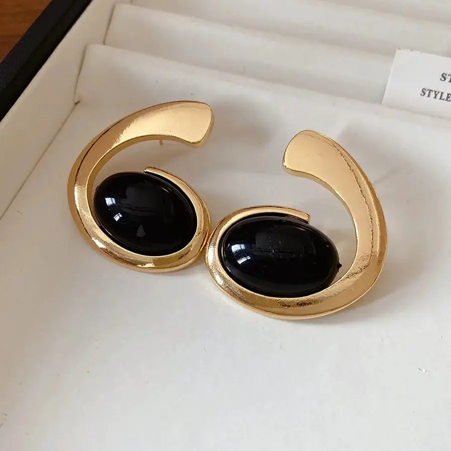 Vintage gold-tone crescent earrings with black oval resin cabochons, pair