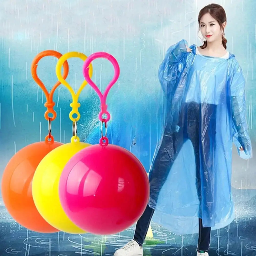 Three compact rain poncho balls with keychain loops in orange, yellow, pink beside a model wearing a blue rain poncho