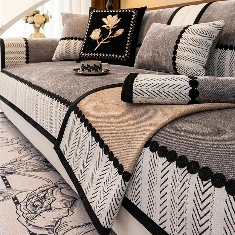 Contrast-hem twill chenille sofa cover in gray and beige with black trim on a living room couch with coordinating cushions