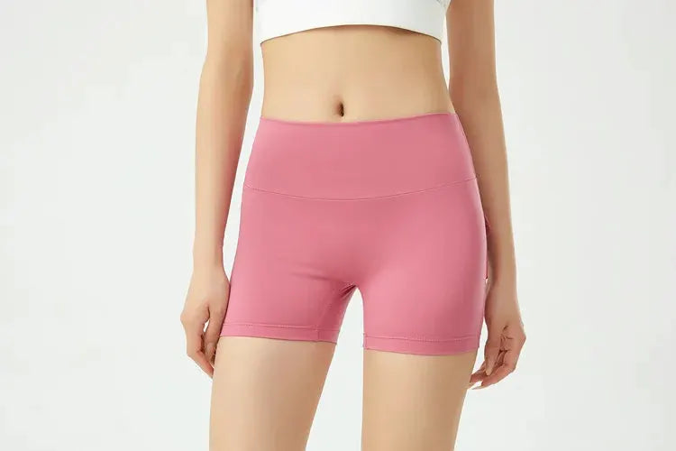 Peach-pink women's fitness shorts, tight yoga-style athletic bottoms for workouts