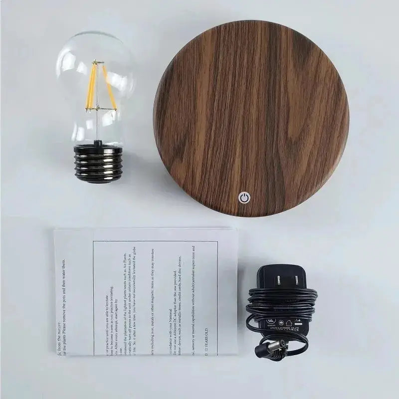 Magnetic levitation lamp with floating glass LED bulb and wooden round base; includes power adapter and manual.