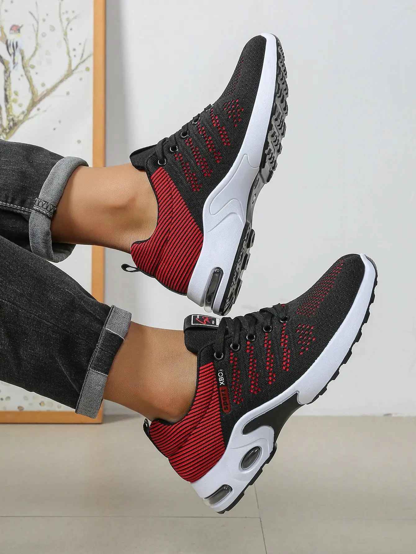 Pair of men's running sneakers, breathable black knit with red accents and non-slip outsole
