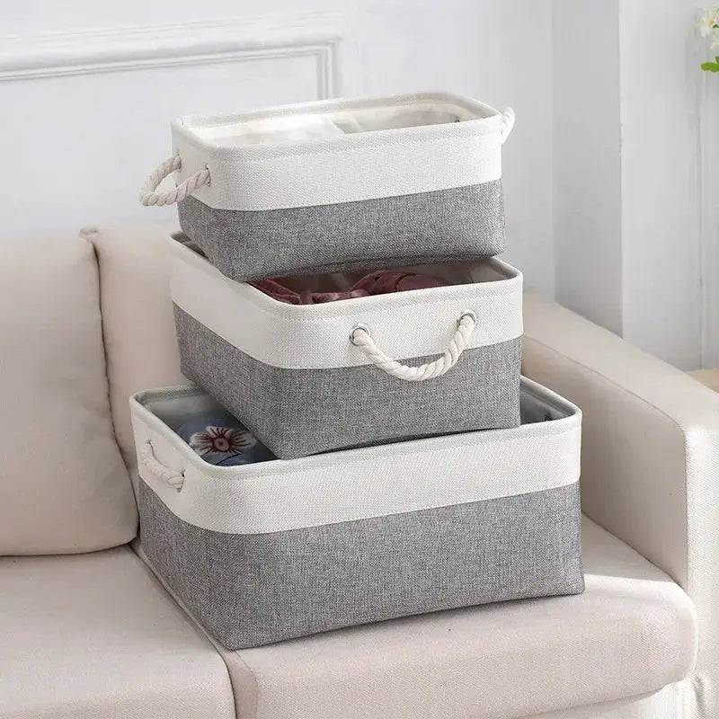 Three grey linen fabric storage baskets with white trim and rope handles, foldable storage organizers for clothes.