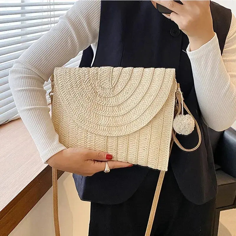 Handmade straw crossbody bag with envelope flap, beige woven texture and pom-pom tassel by Simples Market