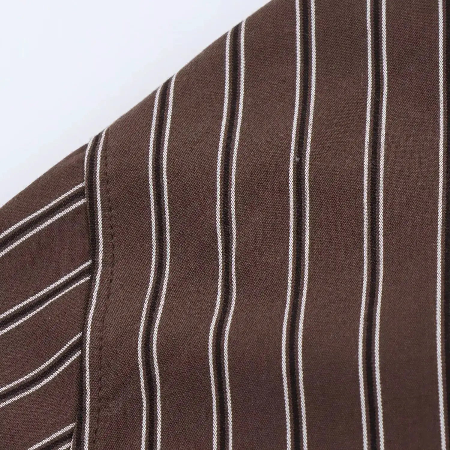 Autumn striped blouse fabric close-up with white vertical stripes.