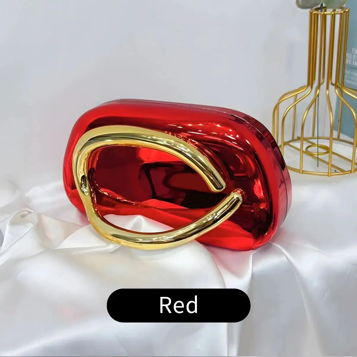 Boxy red acrylic crossbody bag with a gold curved handle by Simples Market