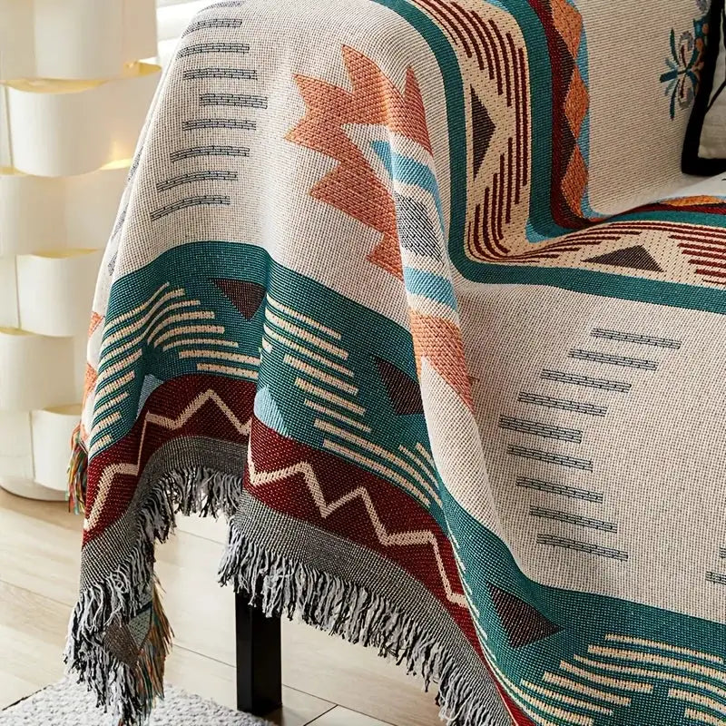 1pc Ethnic sofa cover blanket with teal, red, cream geometric pattern and fringed edges.