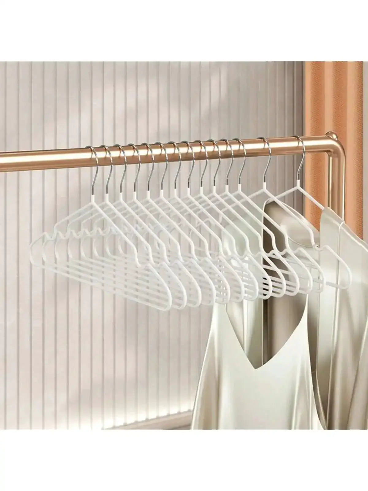 White plastic clothes hangers with metal hooks on a copper rod; 12-piece set