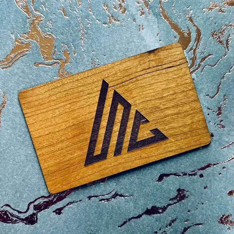 Wooden NFC card by Simples Market with a black laser-engraved logo