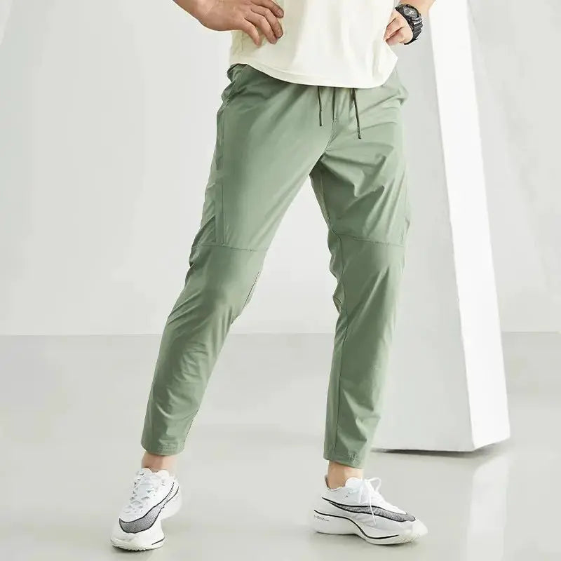 Men's running pants Simples Market, olive green quick-dry joggers with drawstring waist and tapered cuffs.