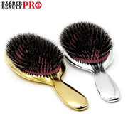 Two luxury gold and silver boar-bristle paddle hair brushes with pink pads from Barber Beauty Pro.