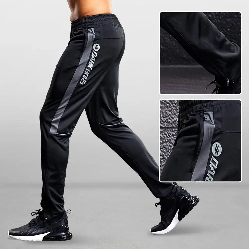 Simples Market men's sport pants in black with gray side stripe and zip pockets.