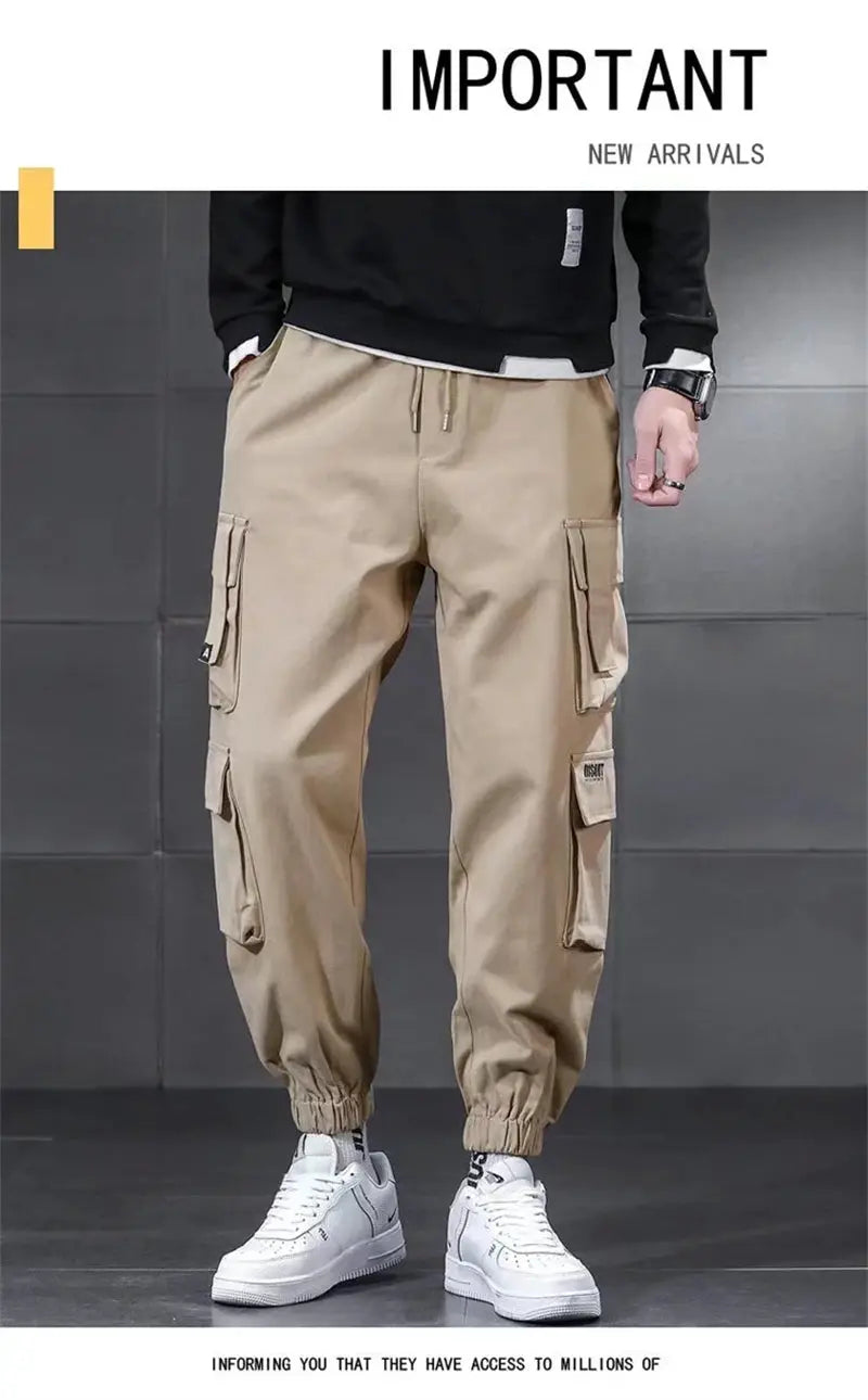 Beige men's cargo pants with multiple utility pockets, drawstring waist and elastic cuffs.