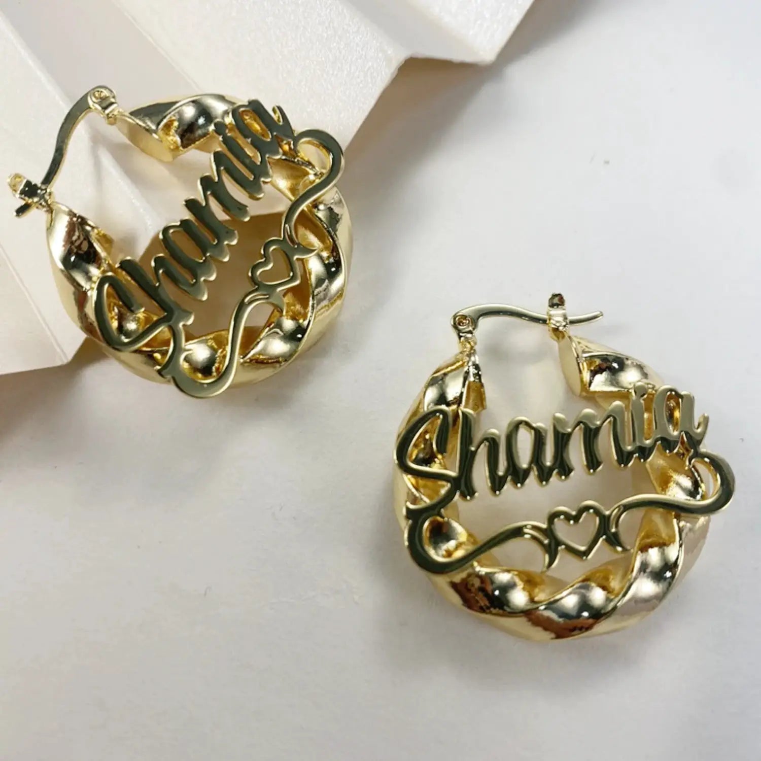 Gold-tone twist hoop earrings with script name charm