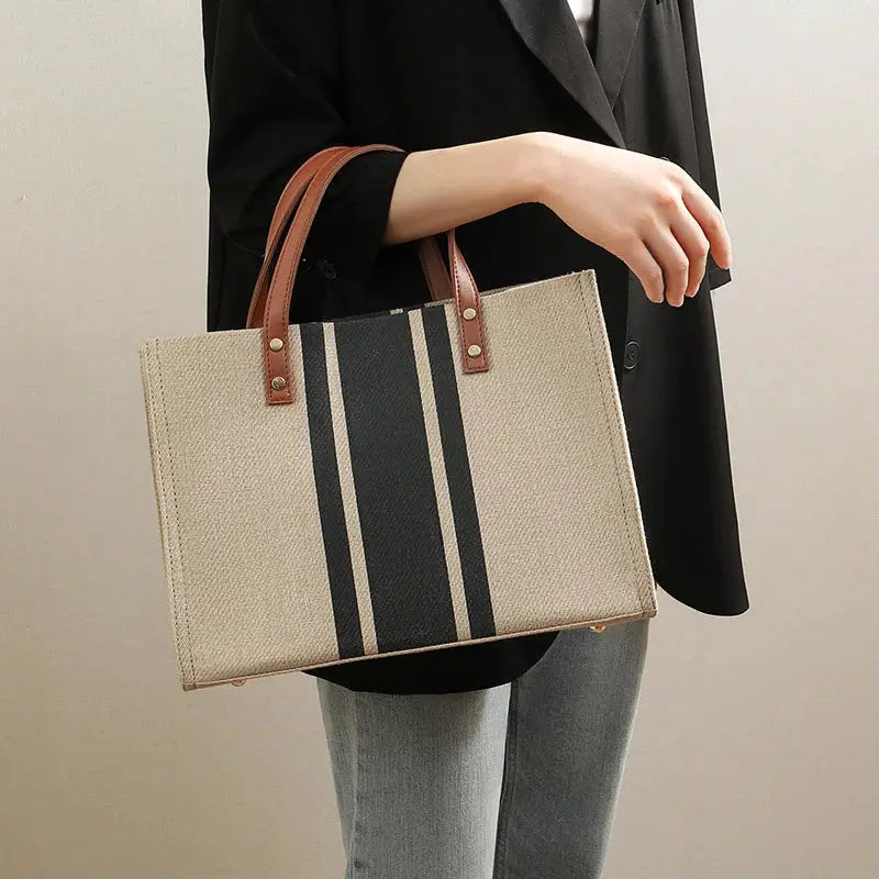Canvas stripe tote bag by Simples Market, beige canvas with dark navy stripe and brown top handles, large capacity.