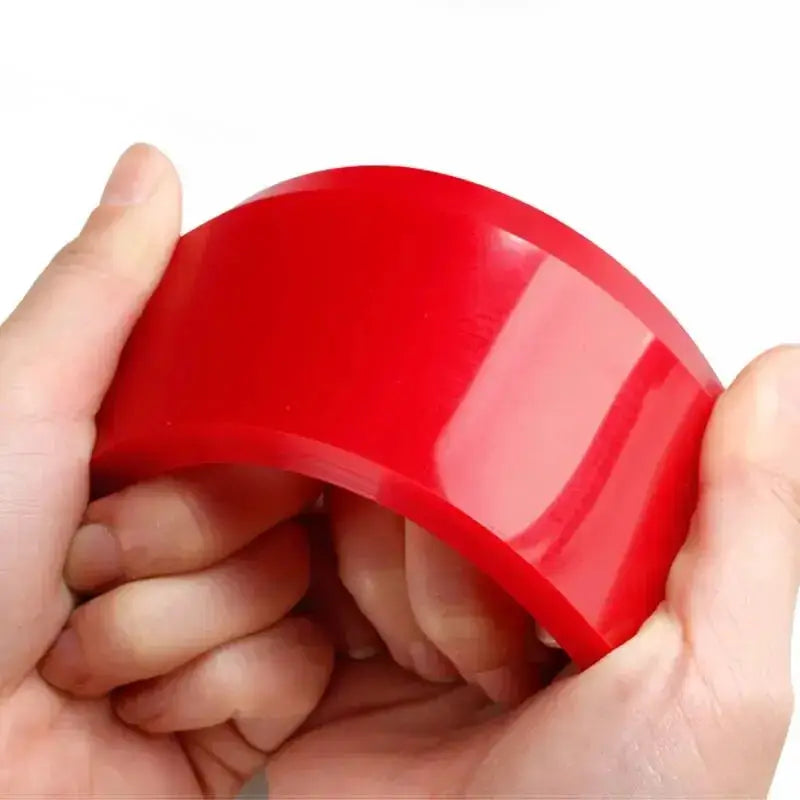 Automotive window film scraper red plastic tool held by hands