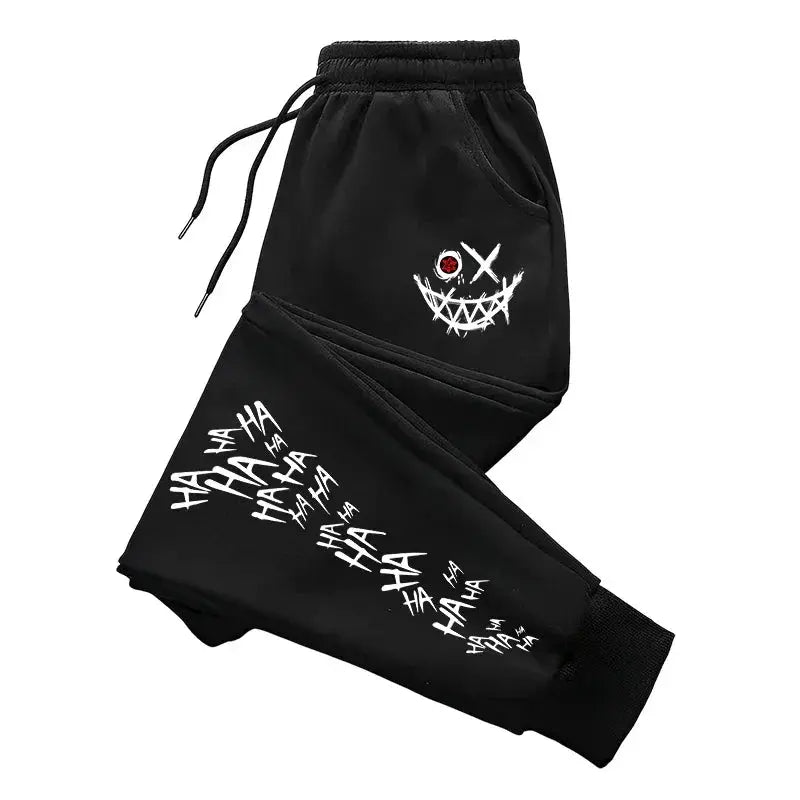 Men's black track pants with white splashed-ink HAHA print and a stitched smile graphic; drawstring waist.