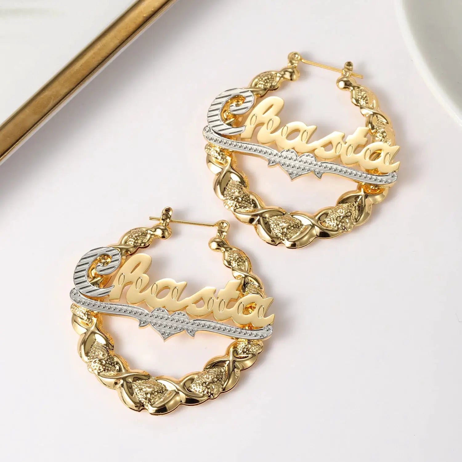 Pair of gold-tone bamboo hoop name earrings with cursive nameplate and silver rhinestone bar