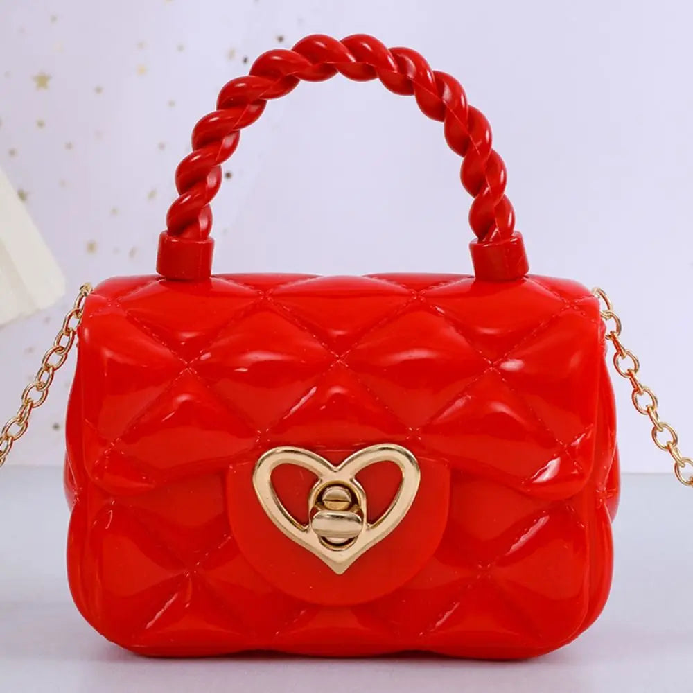 Kids red PU leather crossbody bag with braided handle and heart-shaped gold clasp by Simples Market