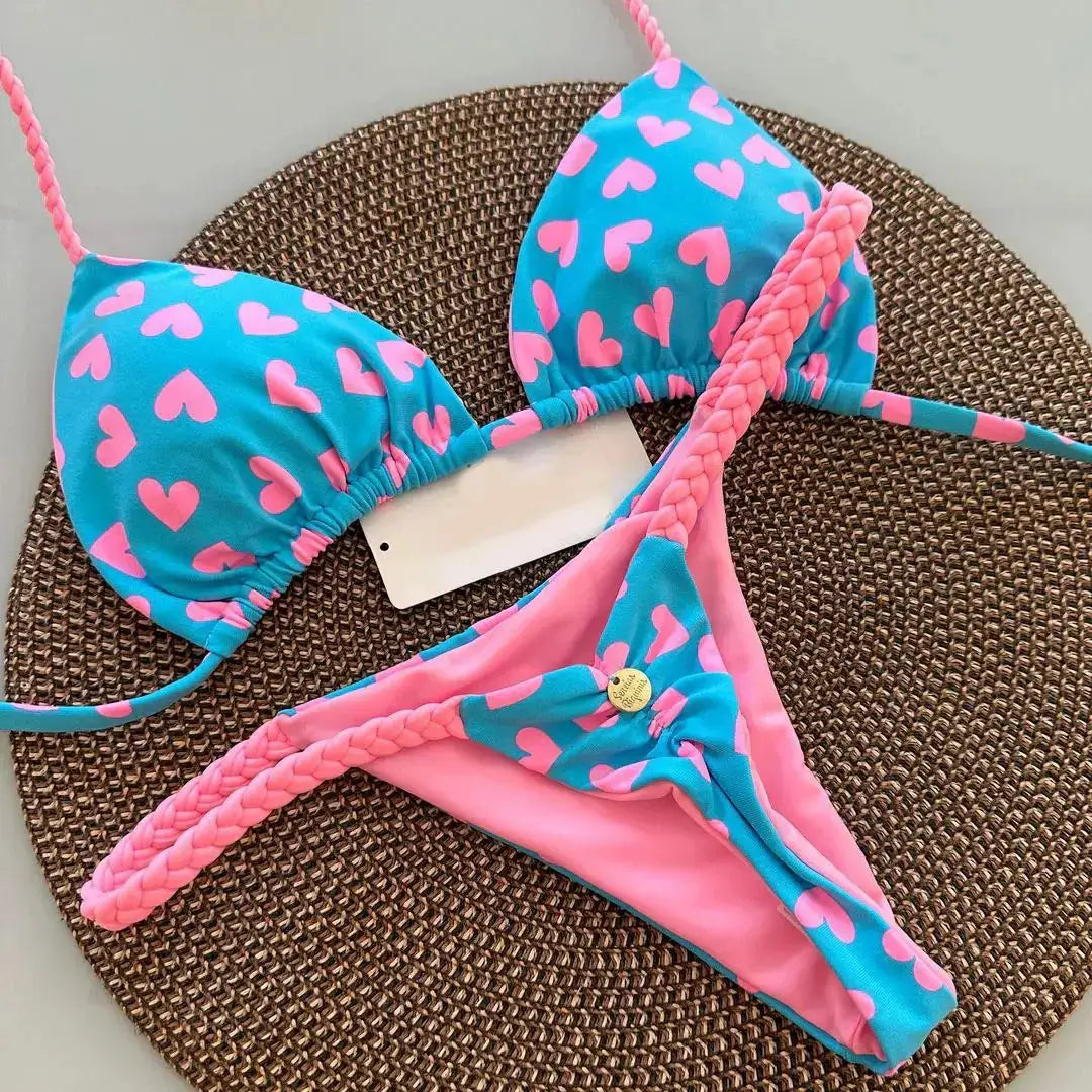 Blue bikini set by Simples Market with pink heart print; triangle top and pink G-string bottom with braided straps.