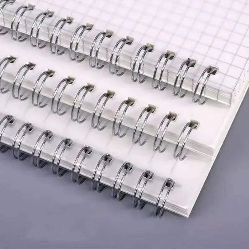 Three A5 grid notepads with silver spiral bindings and white pages