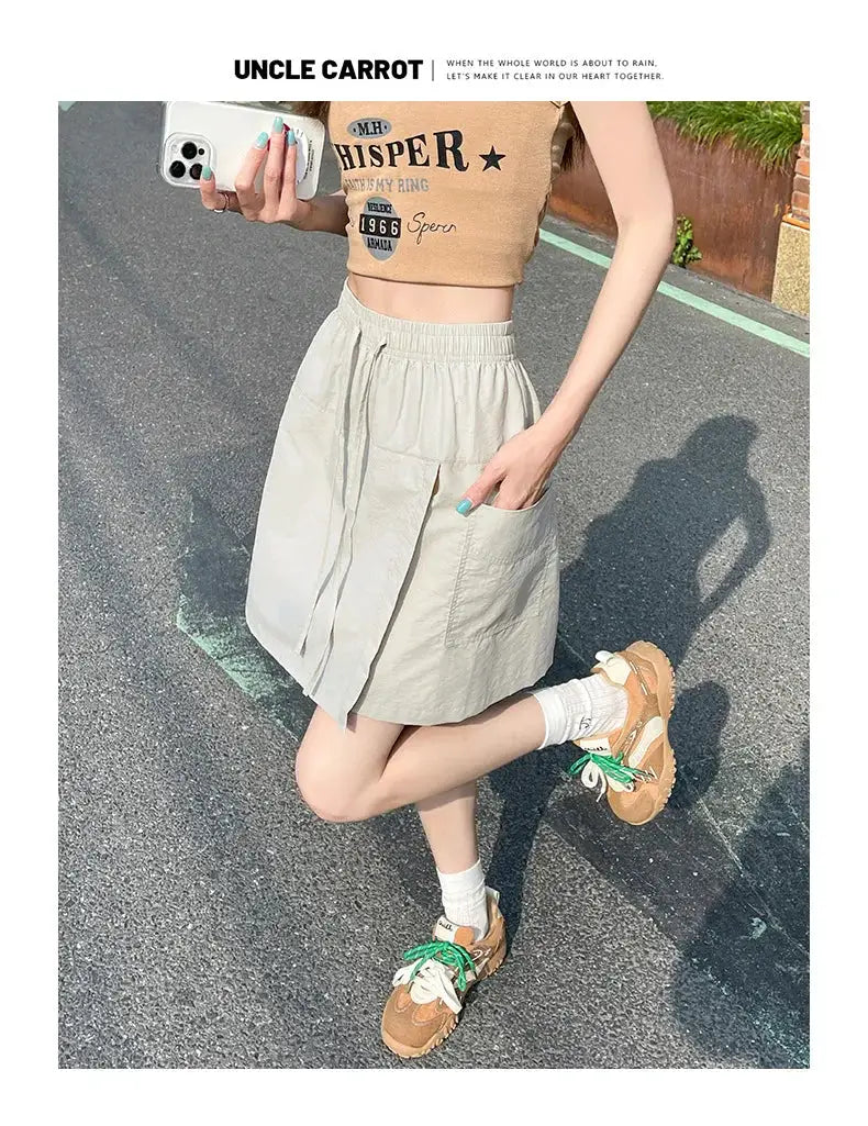 Women's light gray high-waist A-line mini skirt with pockets and a side slit.