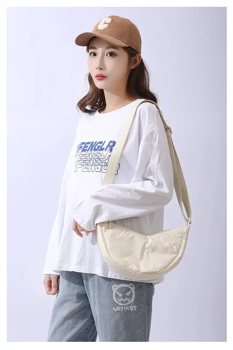 Cream nylon padded crossbody bag for women with wide beige shoulder strap.