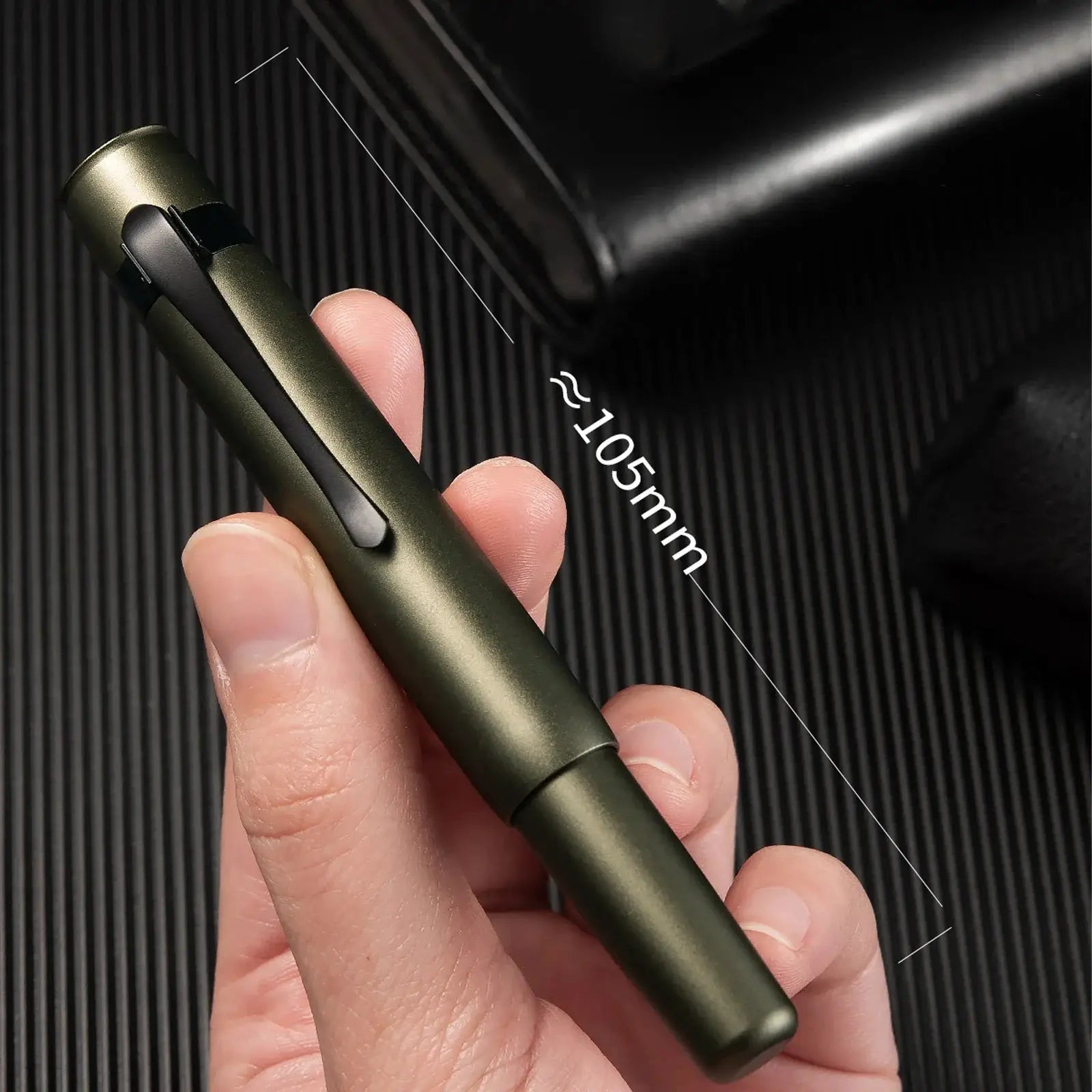 Hongdian M2 fountain pen in olive green with black clip, held in hand