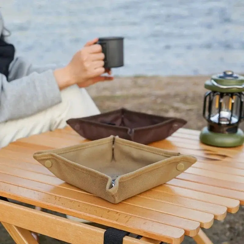 Portable camping organizer trays in tan fabric; two on a wooden table