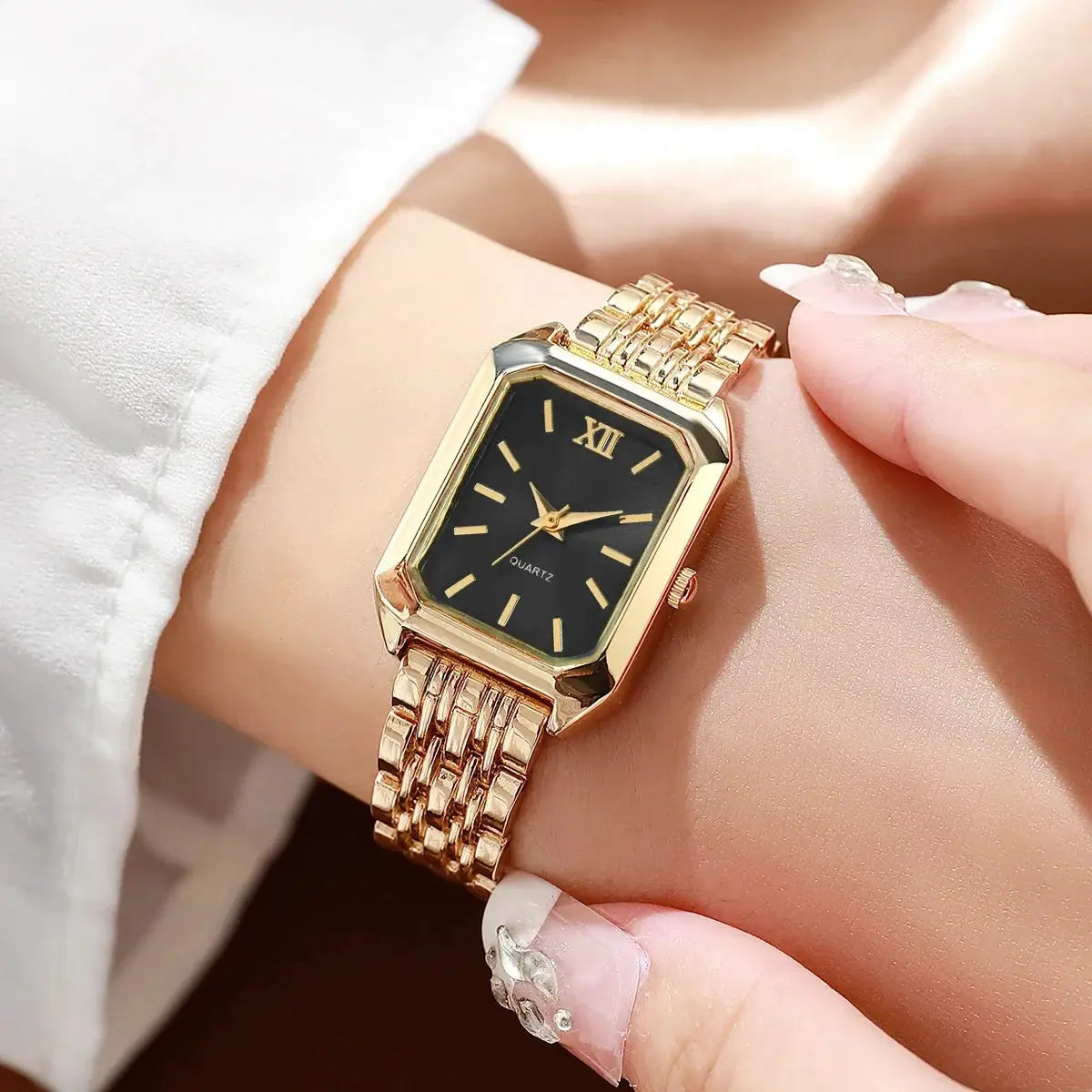 Gold-tone rectangular women's quartz watch with black dial on a linked bracelet