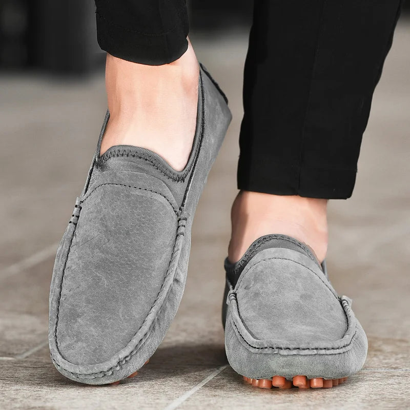 Men's gray suede driving shoes, handmade loafers with a studded rubber outsole.