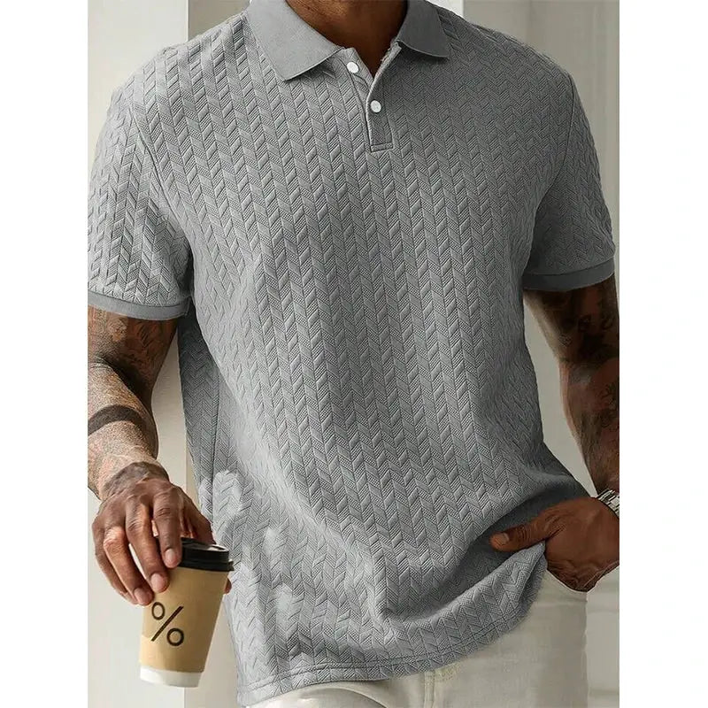 Men's grey polo shirt with chevron pattern and short sleeves.