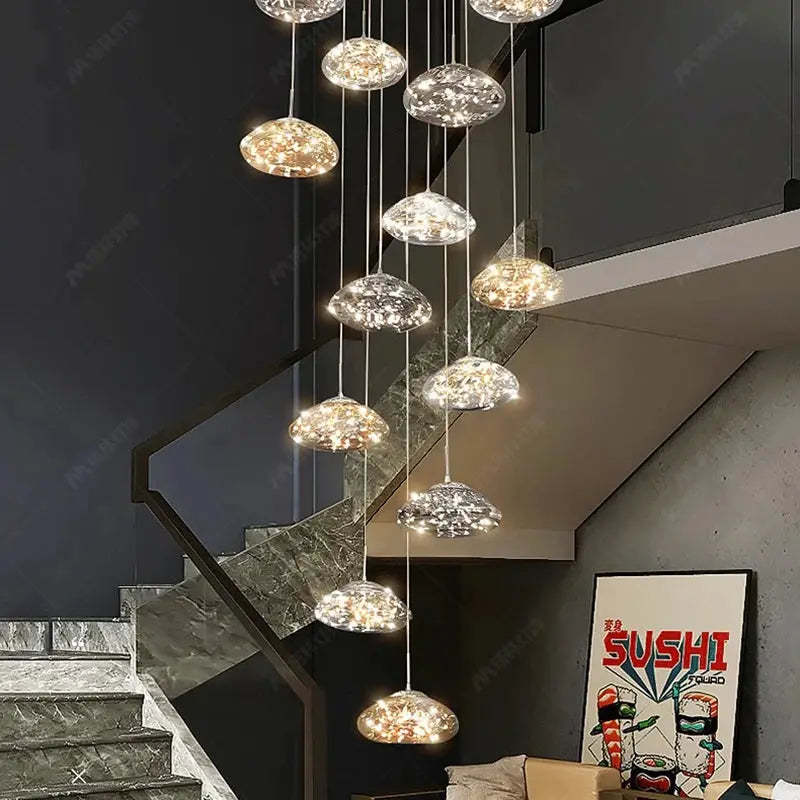 Pendant lights: modern clear glass dome fixtures on staggered cords, hanging over a staircase in a living room.