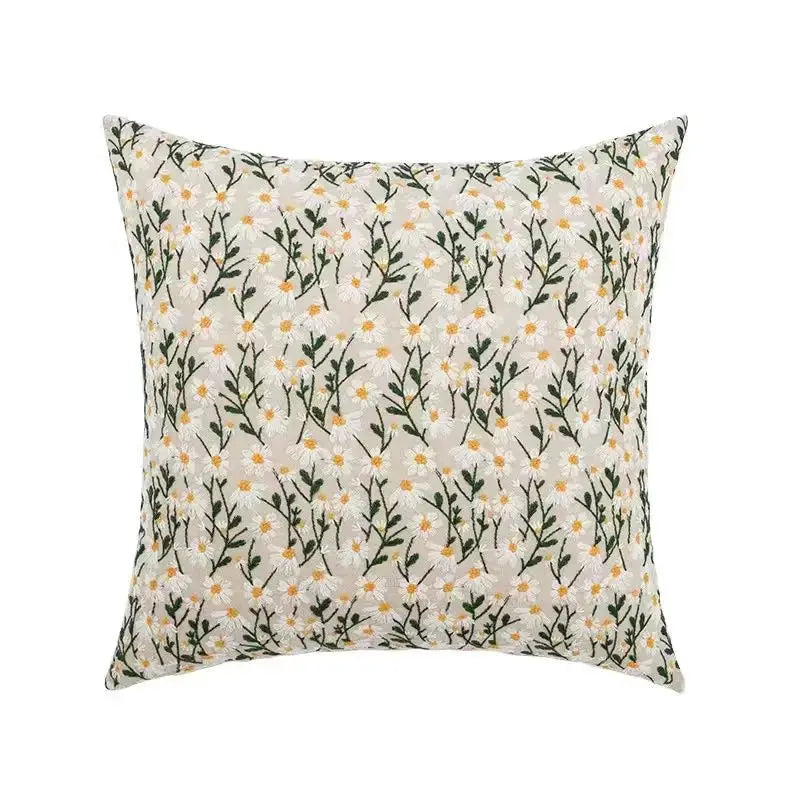 Bohemian embroidered floral pillow cover with white background, yellow-dotted daisies and green stems.