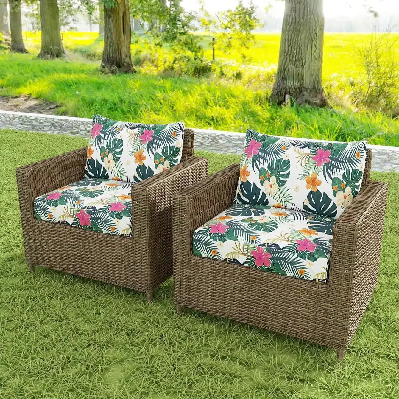 Outdoor tropical print sofa cushion covers on a pair of brown wicker armchairs with matching floral cushions.