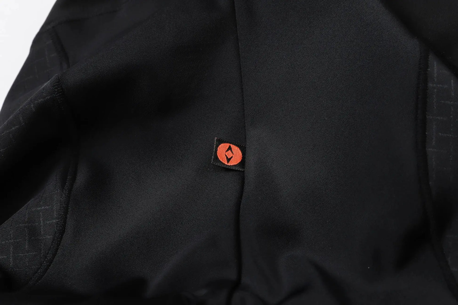 YKYWBIKE men's cycling bib shorts close-up in black fabric with orange logo tag