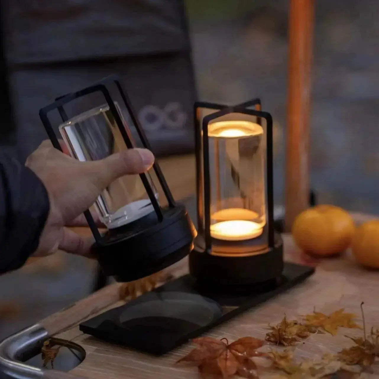 Two GGbingo cordless LED table lamps by Simples Market; black metal frames with glass cylinders and warm ambient light