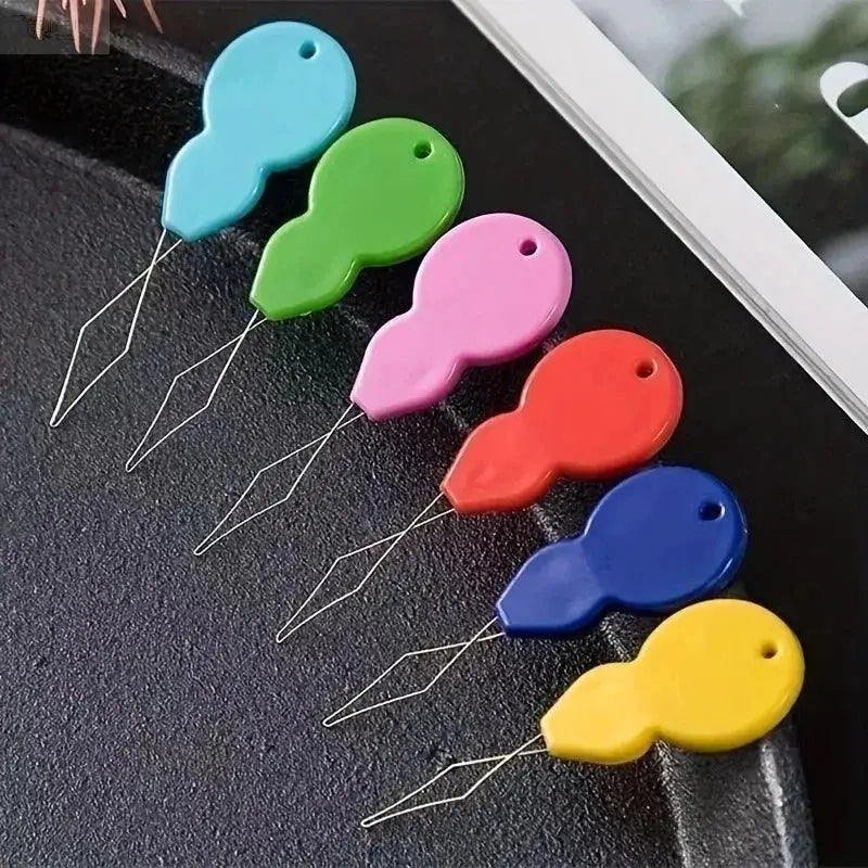 Plastic needle threaders with six color-coded handles for easy hand sewing and threading.