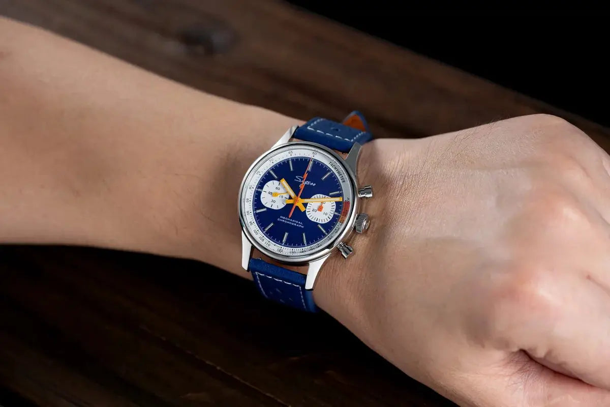 Sugess chronograph watch for men on blue leather strap with blue dial, white subdials, orange hands.