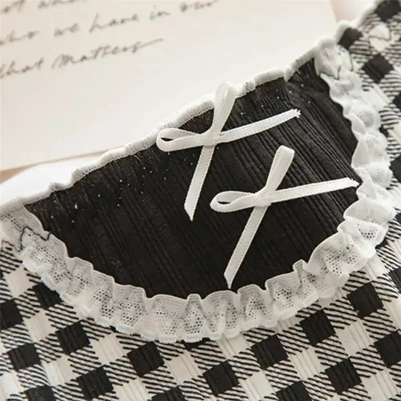Panties for women, black fabric with white lace trim and bow detailing, mid-waist.