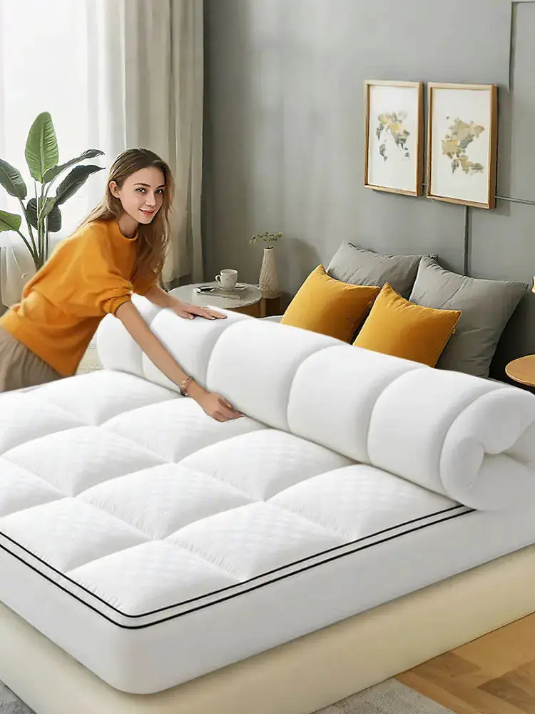 Simples Market waterproof mattress protector in white, thick quilted pad being arranged on bed.