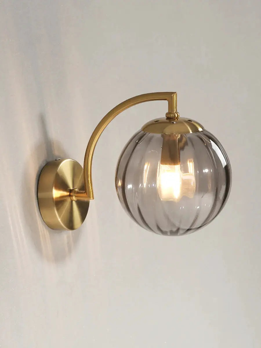 Modern LED wall lamp with brass curved arm and ribbed glass globe shade