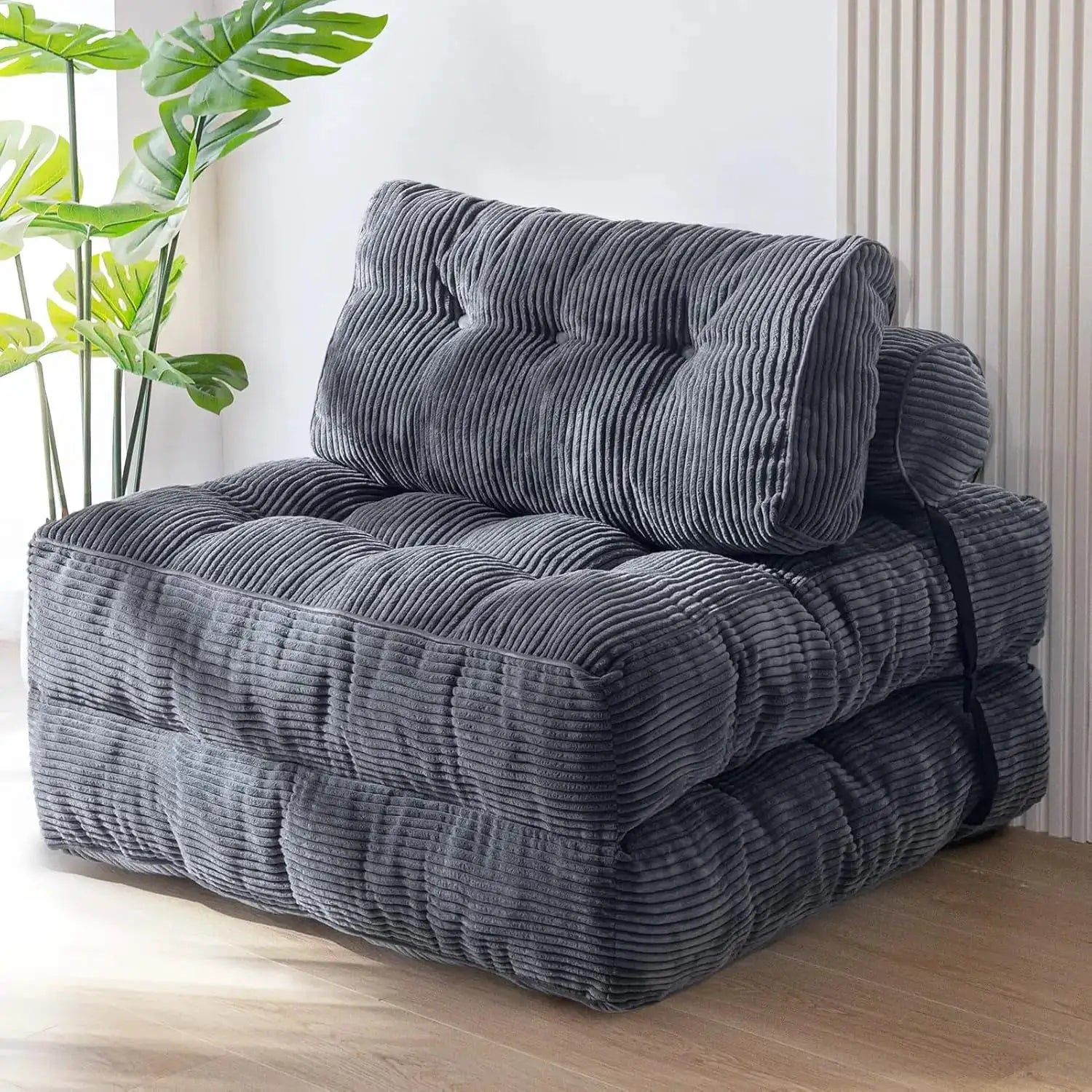 Folding sofa bed by Simples Market in dark gray corduroy with pillow, fold-out sleeper chair.