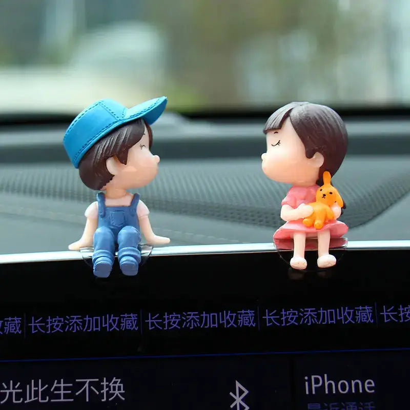 Car dashboard figurines: cute cartoon couple figures, 2, with a blue-cap boy and pink-dress girl holding an orange dog