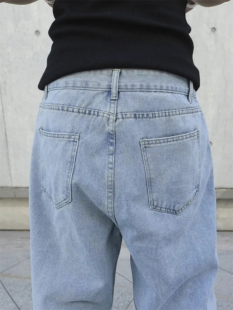 Men's baggy light-blue denim jeans, oversize straight-leg, back view with two back pockets.