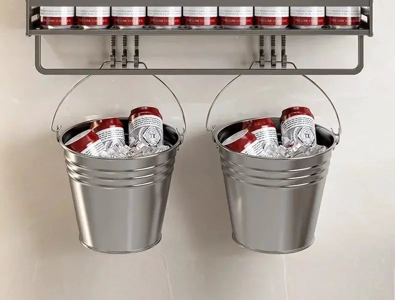 Two aluminum hanging bathroom buckets with handles, filled with cans beneath a metal shelf.