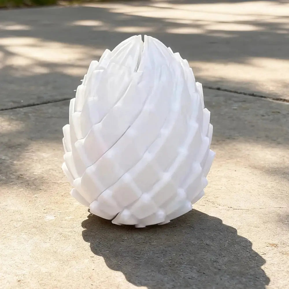 White 3D-printed dragon egg stress-relief model with twistable segments, desk ornament
